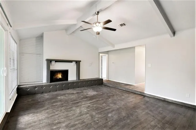 a view of an empty room with window and a fireplace