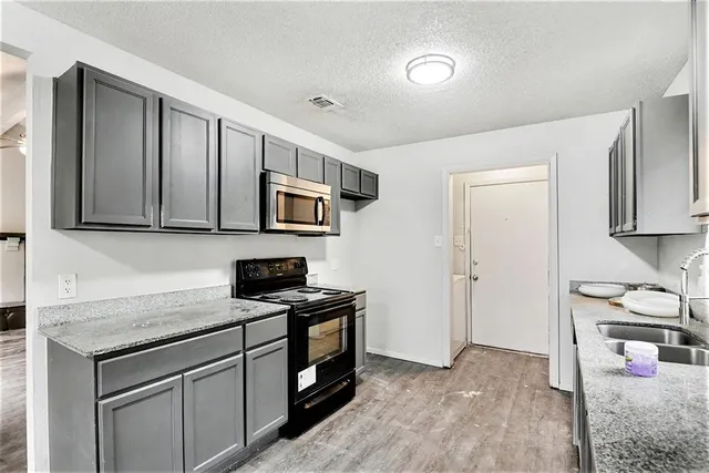 a kitchen with stainless steel appliances granite countertop a stove and a sink