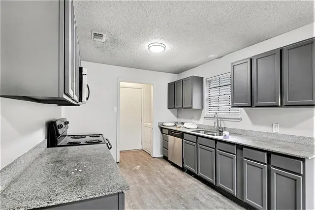 a kitchen with stainless steel appliances granite countertop a sink stove and cabinets
