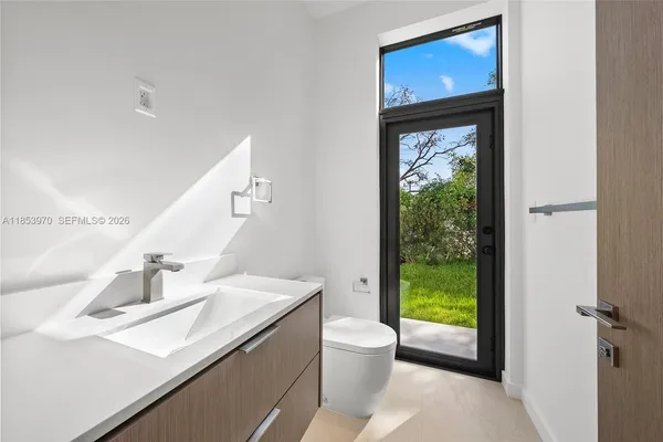 a bathroom with a sink a toilet and a mirror