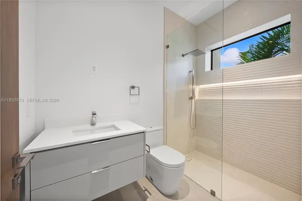 a bathroom with a sink a toilet and shower