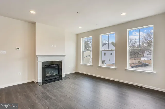 a view of an empty room with exposed radiator and fireplace