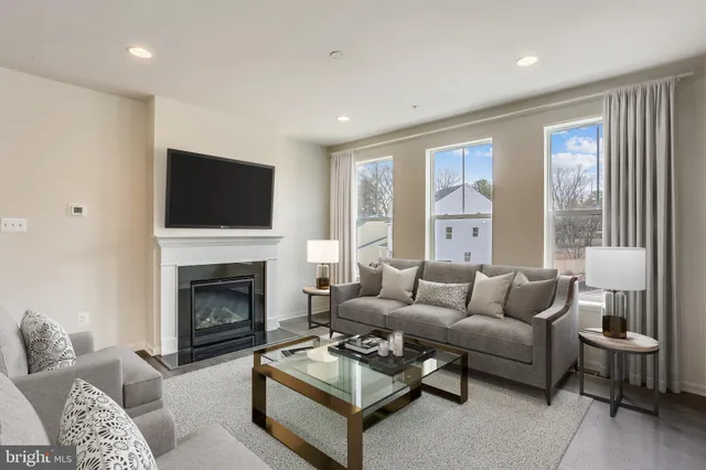 a living room with furniture a flat screen tv and a fireplace