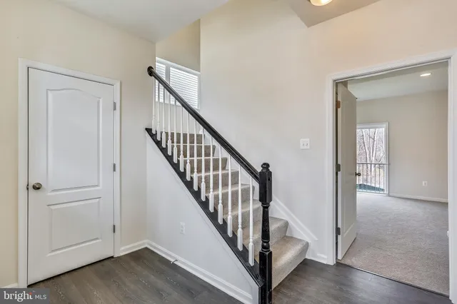 a view of a hallway with wooden floor and entryway