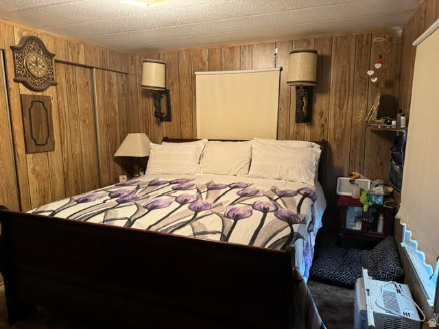 123 North 3rd Manila, UT 84046 - Photo 15 of 15 Wood-paneled room featuring a built-in closet with sliding doors, two wall-mounted sconces, and a ceiling light fixture