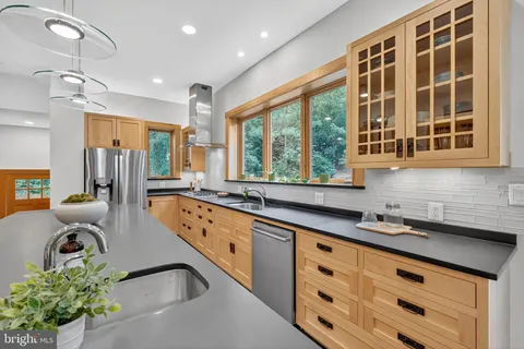 a kitchen with counter top space a sink a stove and a window