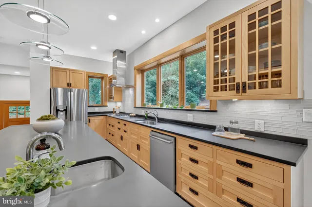 a kitchen with counter top space a sink a stove and a window