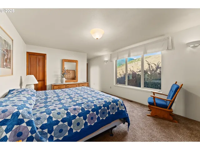 a bedroom with a bed a couch and large window