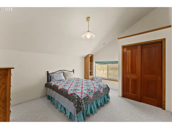 a bedroom with a bed dresser and a window