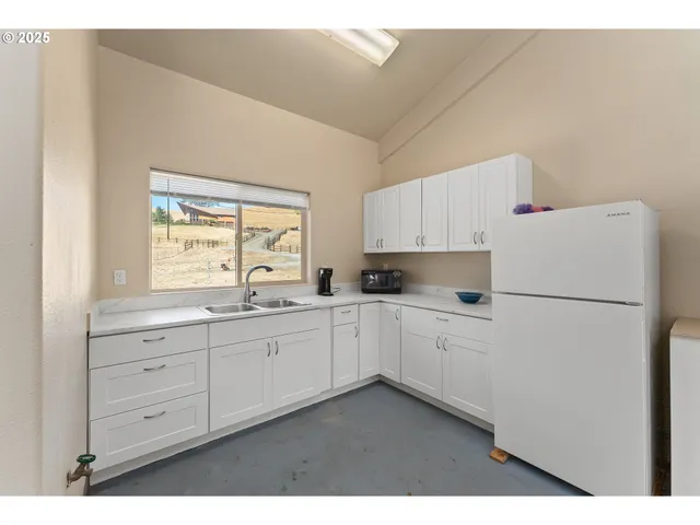 a kitchen with cabinets appliances a sink and a window