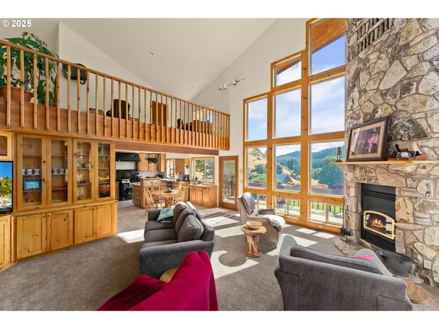 a living room with furniture fireplace and floor to ceiling windows