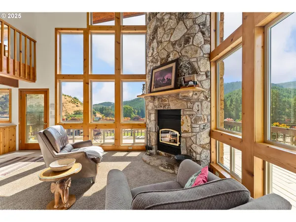a living room with furniture a fireplace and a large window