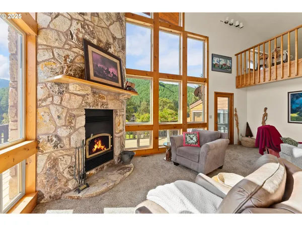a living room with furniture a fireplace and floor to ceiling windows