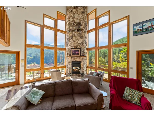 a living room with furniture large windows and a fireplace