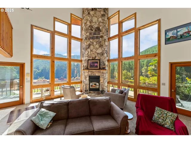 a living room with furniture large windows and a fireplace