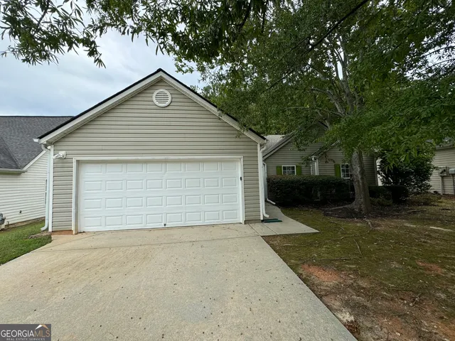 a front view of house with garage and trees