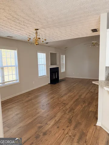 an empty room with windows and fireplace