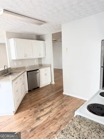 a front view of house with yard and trees in the background