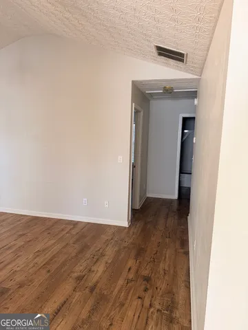a view of a small space with wooden floor and a hallway