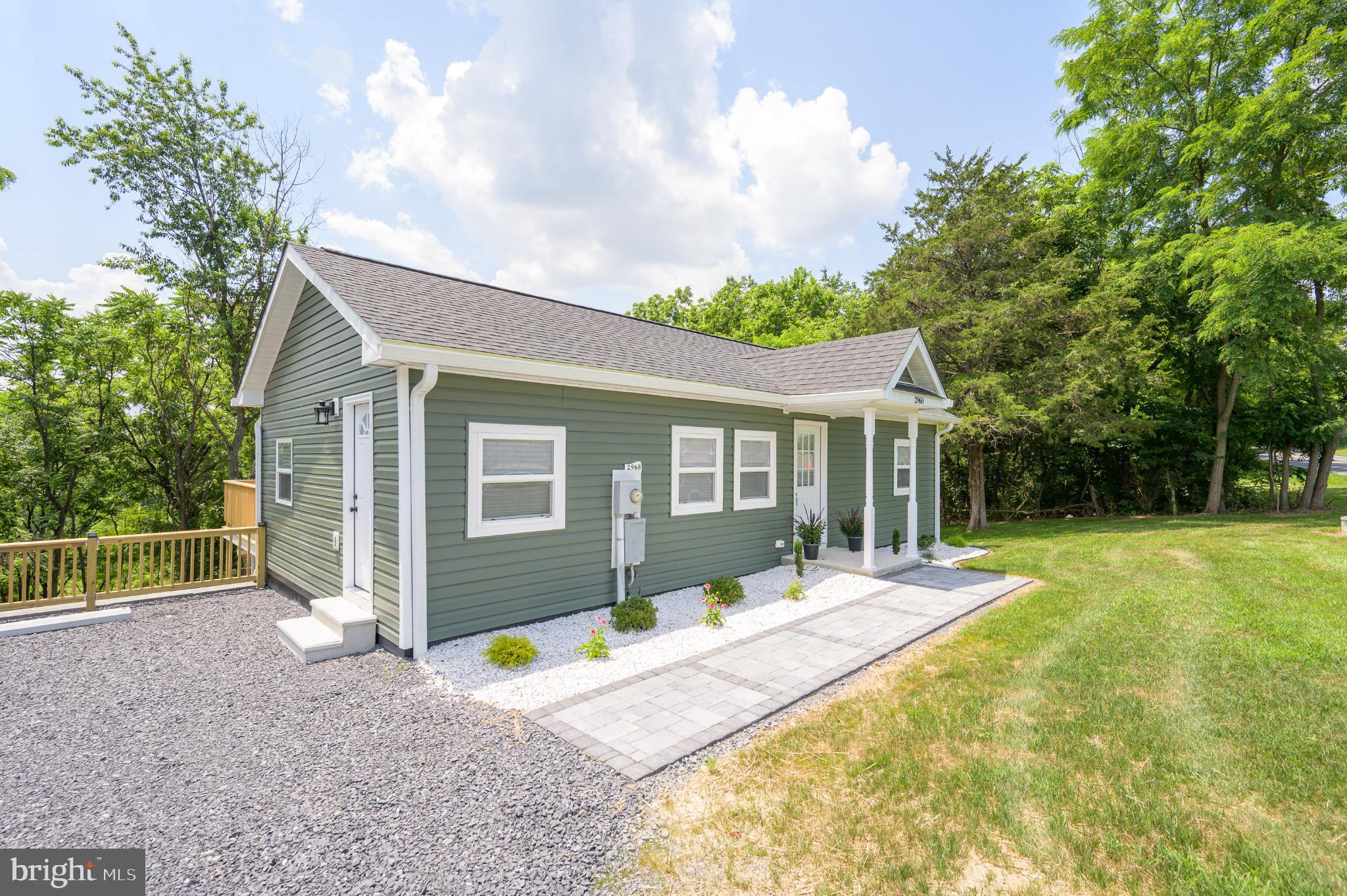 Charming green cottage with serene surroundings.
