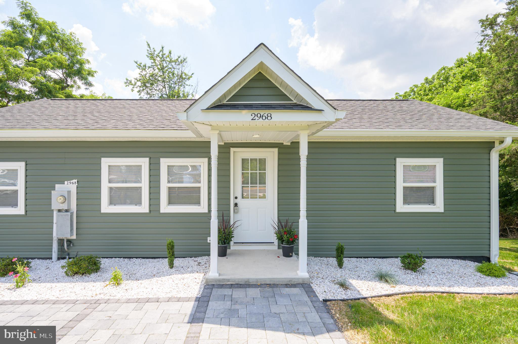 Charming green home with inviting entrance.