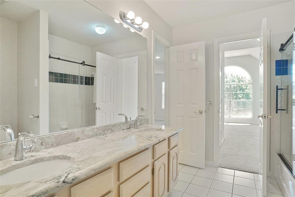 132 Rustic Meadow Way Coppell, TX 75019 - Photo 23 of 39 a bathroom with a granite countertop sink a large mirror and a shower