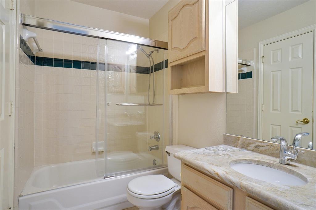 132 Rustic Meadow Way Coppell, TX 75019 - Photo 27 of 39 a bathroom with a granite countertop sink a toilet and shower