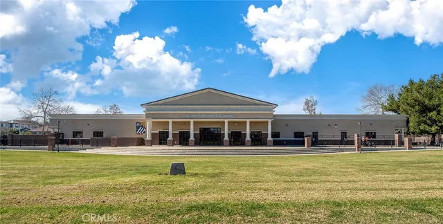 a view of a white house with a yard and potted plants