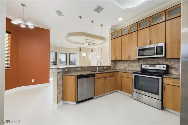 a kitchen with stainless steel appliances granite countertop a stove a sink and a microwave