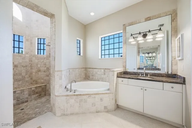 a bathroom with a granite countertop bathtub sink vanity and mirror