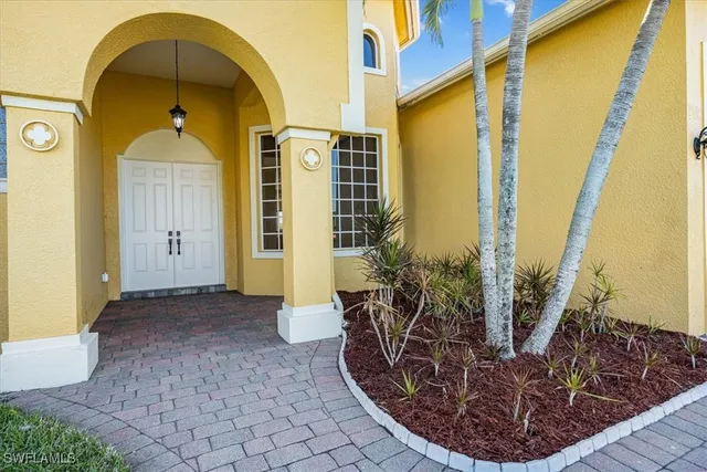 a view of a entryway door with potted plants