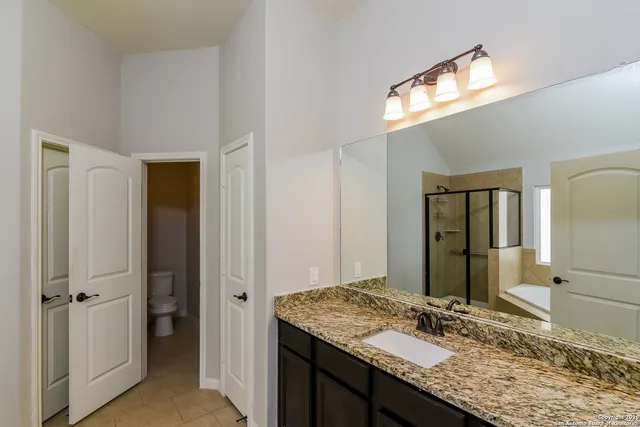 a bathroom with a granite countertop sink and a mirror
