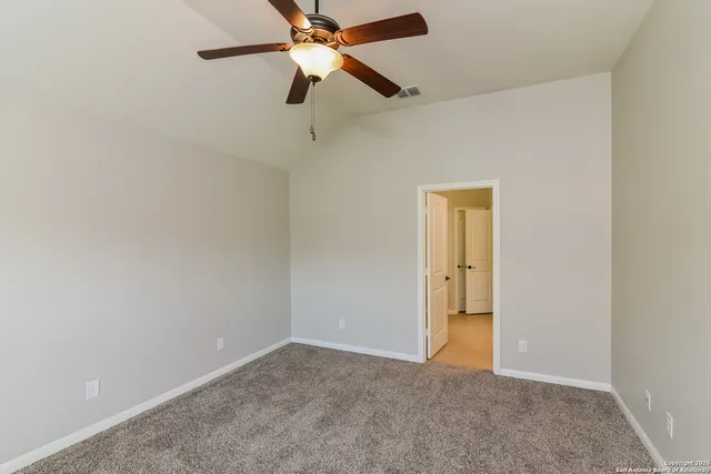 an empty room with closet and a chandelier fan