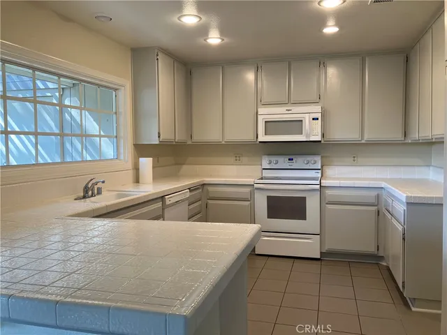 a kitchen with a stove sink and cabinets
