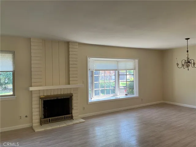an empty room with windows and a fireplace