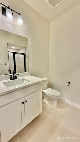 a bathroom with a toilet a sink and mirror
