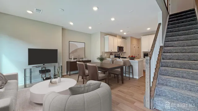a living room with furniture a flat screen tv and kitchen view