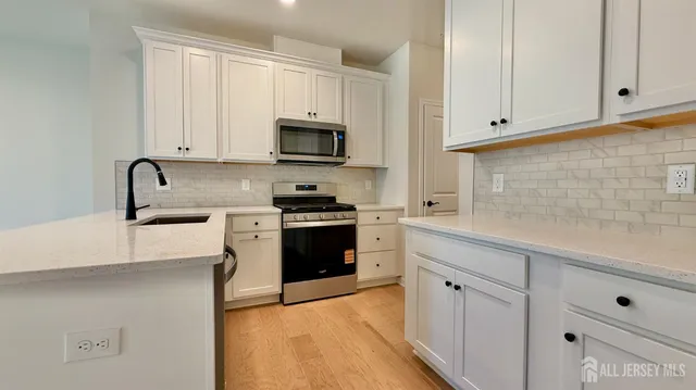 a kitchen with white cabinets and stainless steel appliances