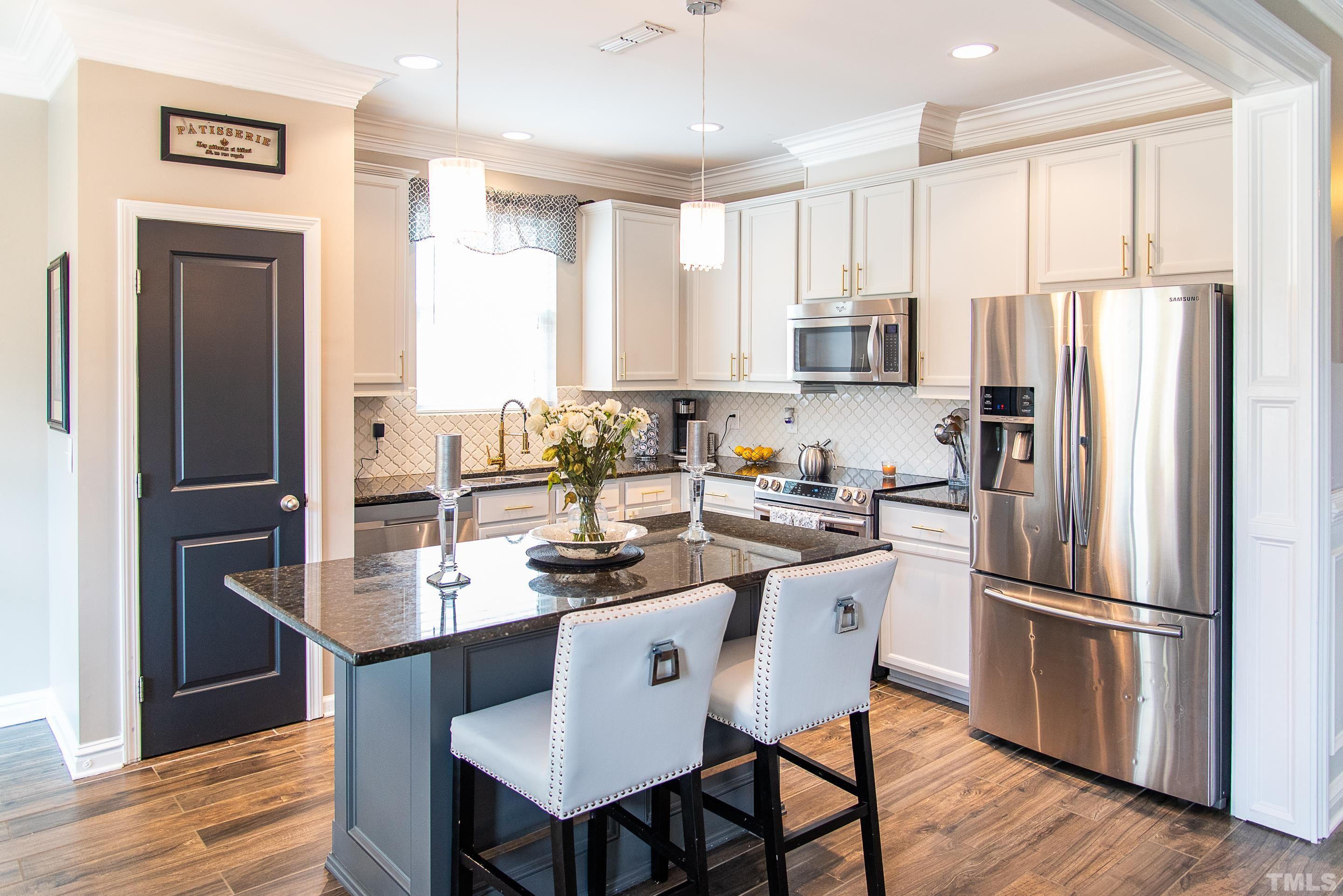 612 Hope Valley Road Knightdale, NC 27545 - Photo 18 of 56 a kitchen with stainless steel appliances granite countertop a refrigerator a stove a sink a dining table and chairs with wooden floor