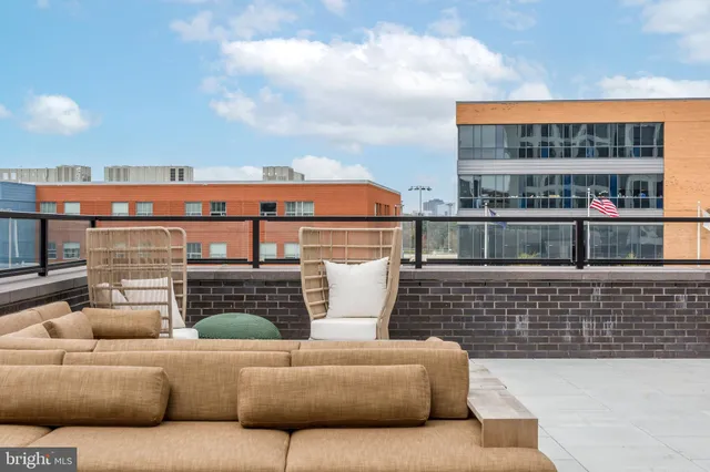 a roof deck with couches and potted plants