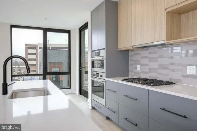 a kitchen with stainless steel appliances granite countertop a stove a sink and a refrigerator