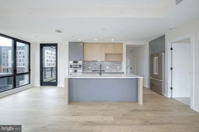 a view of kitchen with stainless steel appliances granite countertop a stove and a sink