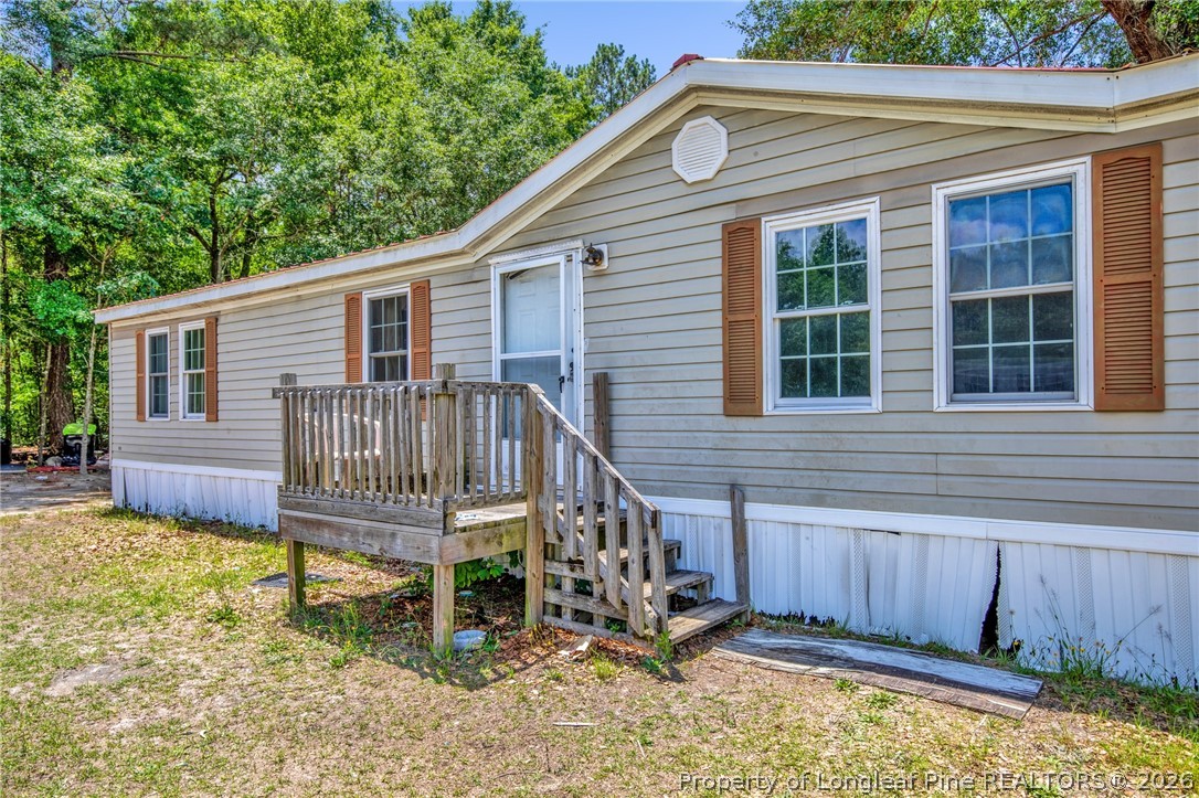 4705 Hickory Ridge Road Parkton, NC 28371 - Photo 5 of 37 a view of a house with a yard chairs and wooden fence