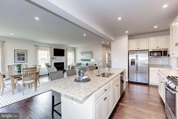 a large kitchen with stainless steel appliances lots of counter space and wooden floor