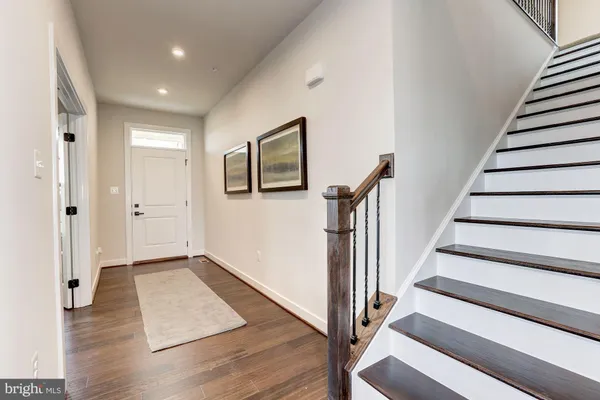 a view of a hallway with wooden floor and staircase