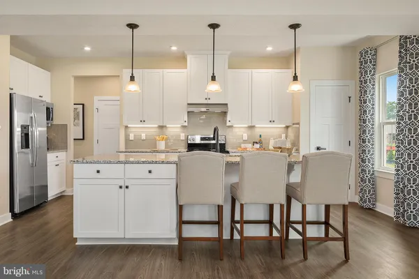 a kitchen with stainless steel appliances granite countertop a stove a refrigerator a oven a sink with island chairs and wooden floor