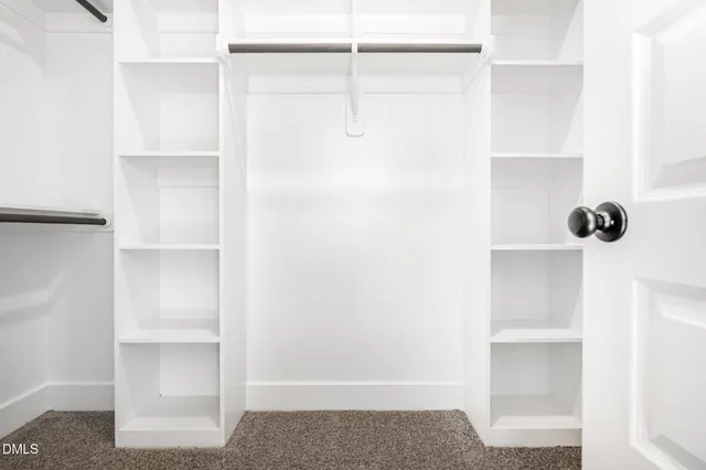 a view of walk in closet with empty racks