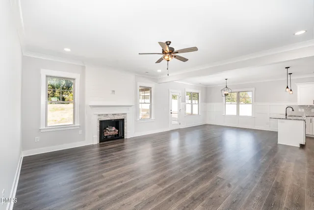 a view of an empty room with a window and fireplace