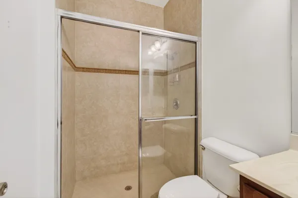 an empty room with wooden floor chandelier fan and windows