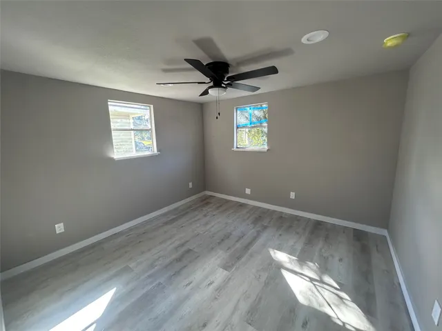 an empty room with a window and a ceiling fan